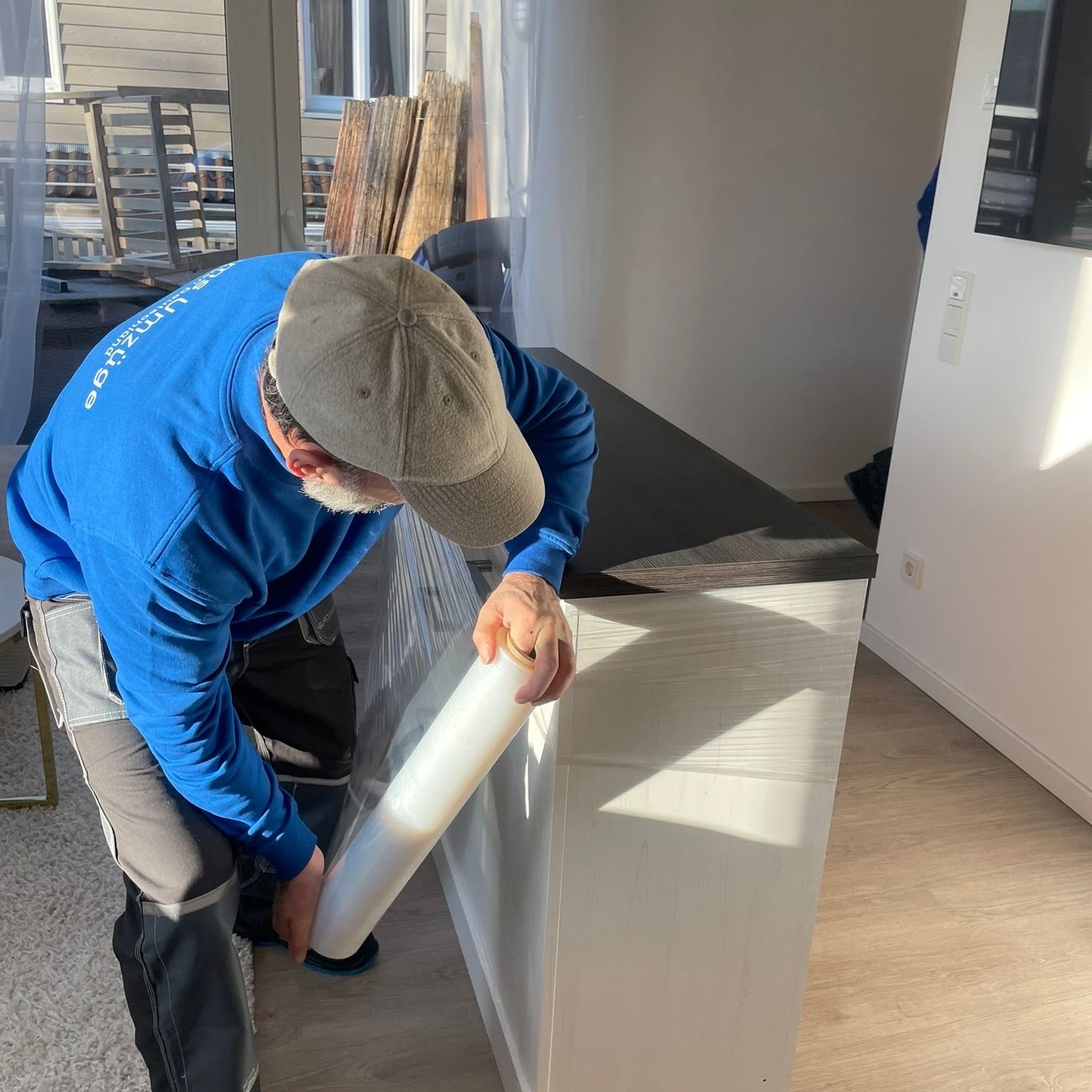 Mitarbeiter von Böhms Umzüge sichert ein Sideboard mit Stretchfolie