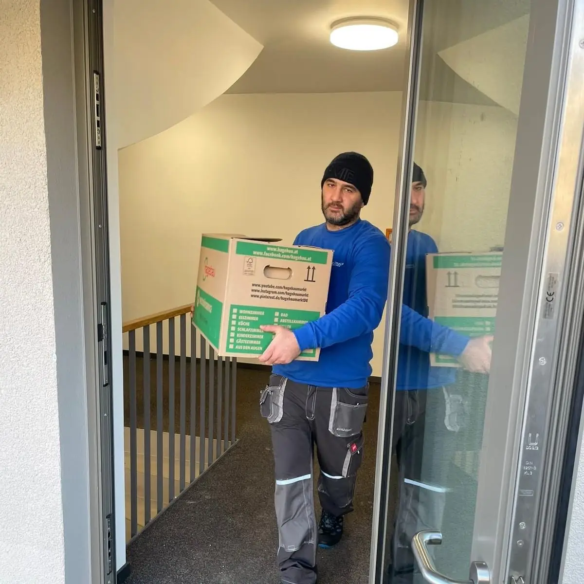 Böhms Umzüge trägt einen Umzugskarton